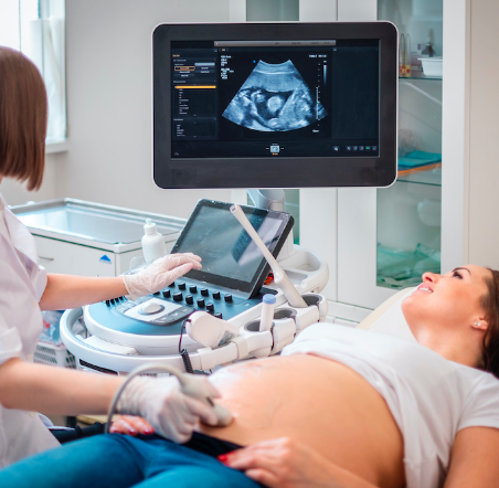 Médico realizando un ultrasonido a una mujer embarazada