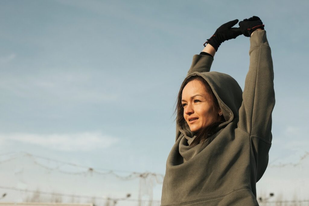 portrait of a beautiful adult woman outdoors in sunny weather. close-up, woman holding her hands above her head . High quality photo