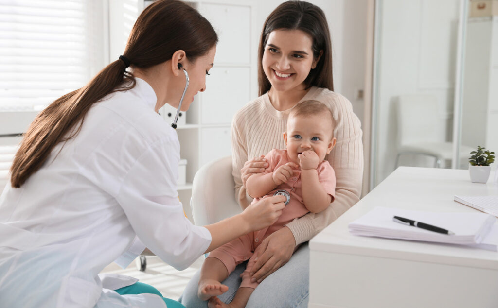 Médica pediatrica atendiendo a un bebé con su madre