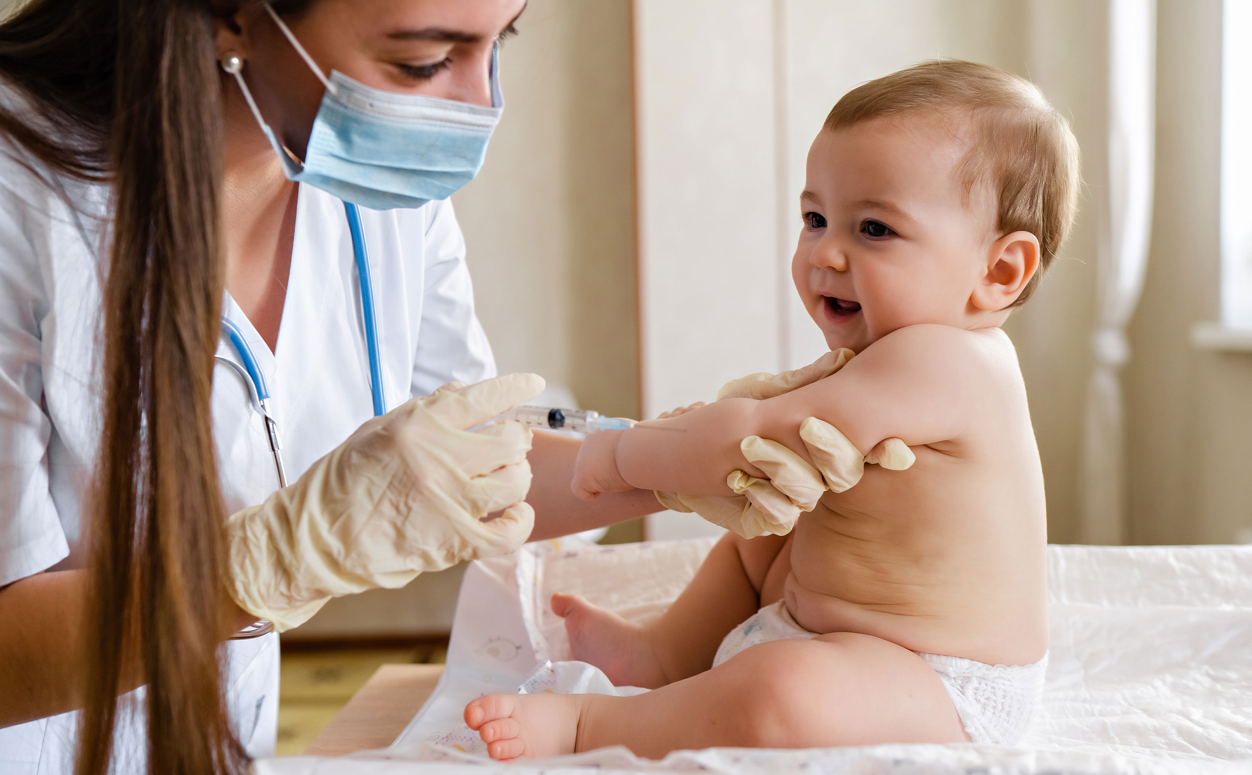 Médica inyectando una vacuna de la cartilla de vacunación a un bebé