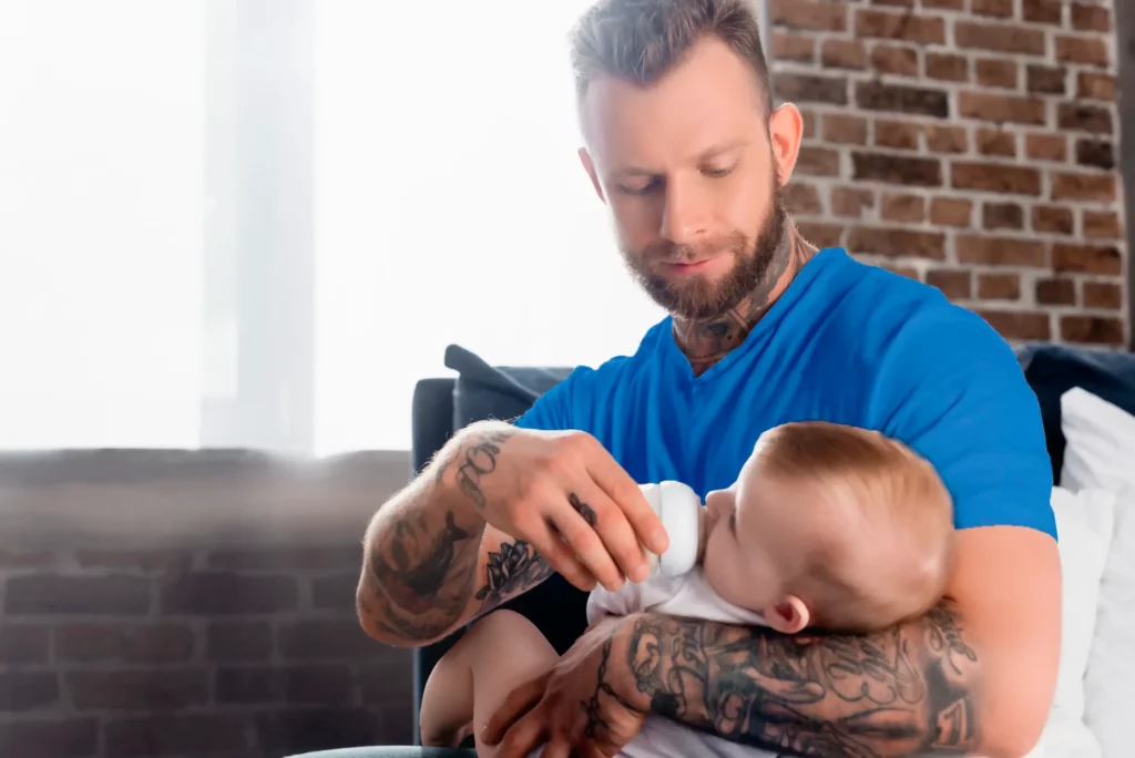 Papá cargando a su bebé posterior a la circuncisión