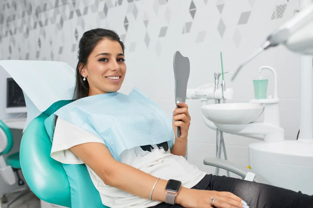 Mujer sonriendo tras un procedimiento de cirugía maxilofacial.