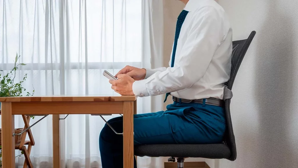 Hombre usando celular y teniendo una buena postura