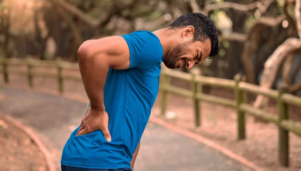 Hombre haciendo ejercicio con dolor, que es mialgia, por no haber estirado correctamente.