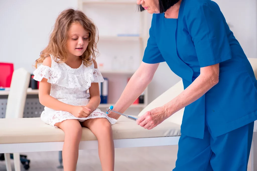 Neurocirujano pediatra realizando un examen físico a una paciente.