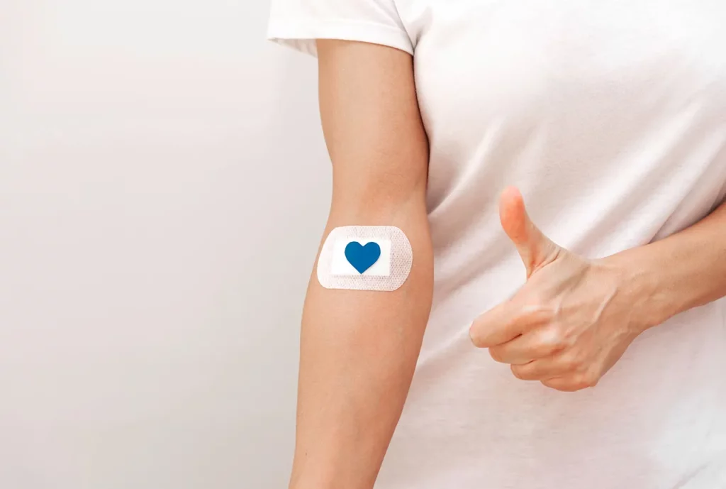 Persona con un parche en el brazo, tras cumplir los requisitos para donar sangre y realizar el procedimiento