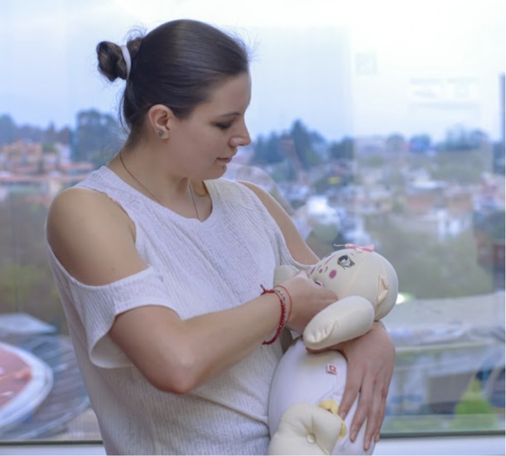 Mujer sosteniendo un muñeco de trapo como si fuese un bebé lactando Mujer sosteniendo un muñeco de trapo como si fuese un bebé lactando