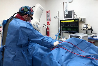 Médico realizando una cardioversión en un paciente.