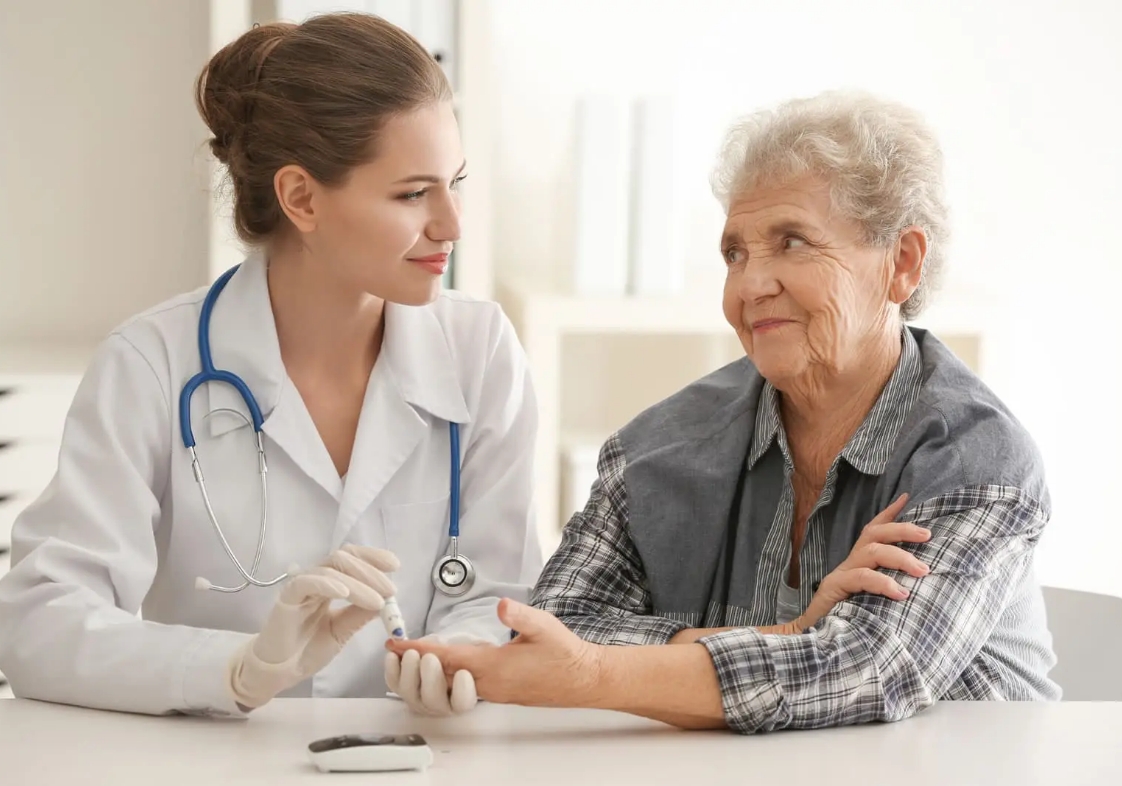 Diabetólogo tomando la glucemia en sangre de una paciente mayor de edad