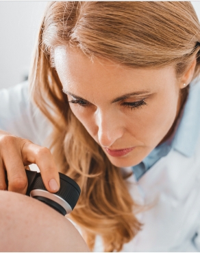 Doctora observando piel de paciente con dermatoscopio