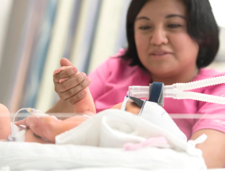 Enfermera tomando la mano de bebe