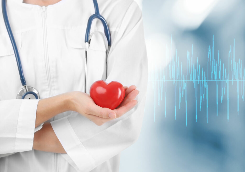 Doctora sostiene en su mano una figura de corazón para representar cómo prevenir un infarto.