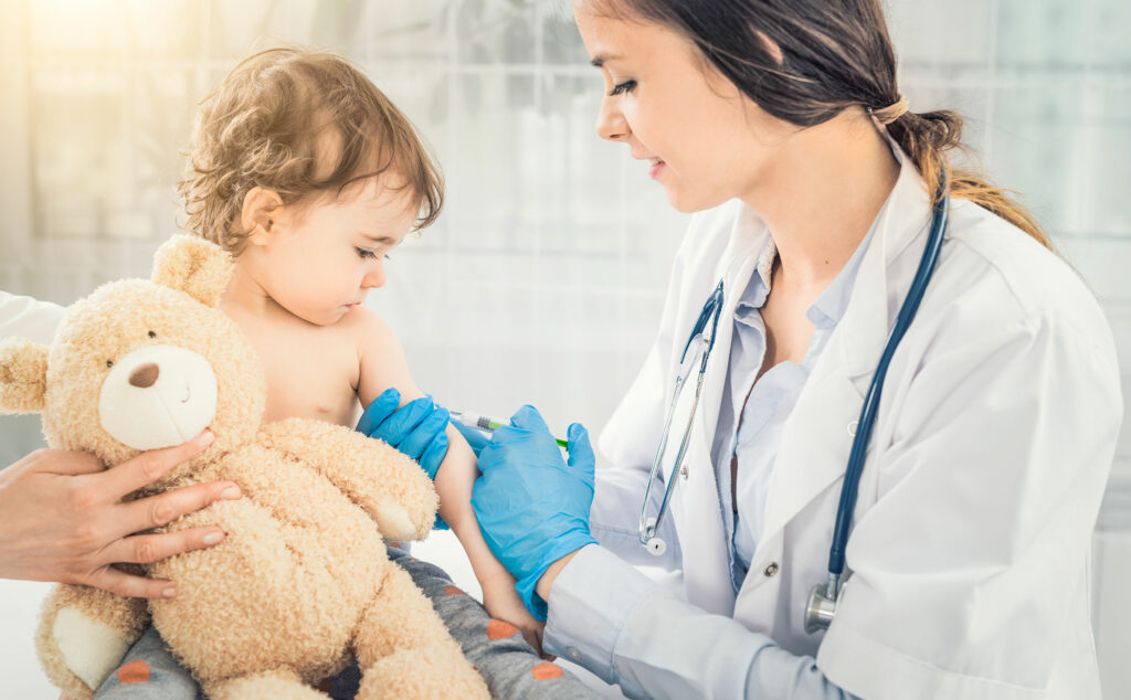 Médica inyectando una vacuna a niño por su esquema de vacunación