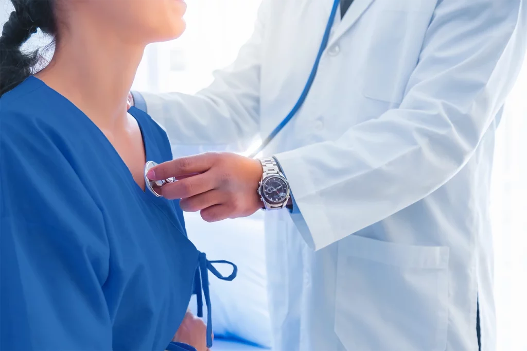 Doctor holding a stethoscope to perform a check-up on a patient