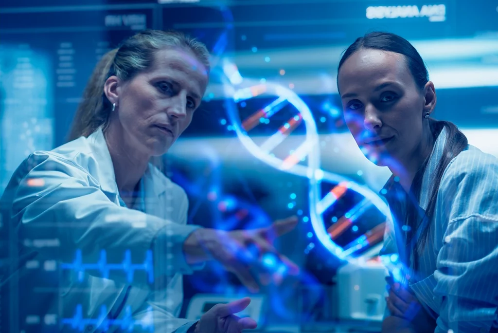 Dos doctoras revisando una imagen de ADN para representar cómo funciona la medicina de precisión en el tratamiento de múltiples enfermedades.