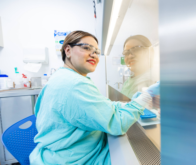 Laboratory professional at ABC Medical Center working in a biosafety cabinet as part of the precision medicine process.