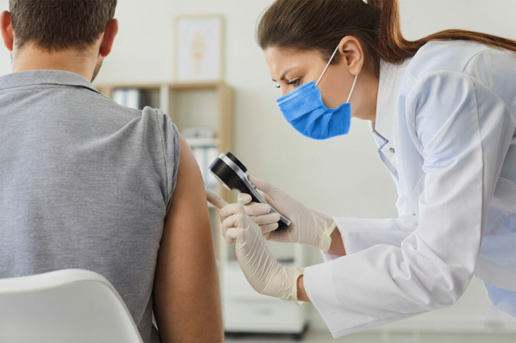 Dermatóloga revisando la evolución del sarpullido en la piel de un paciente que está sentado en su consultorio.