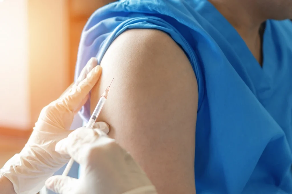 Especialista aplicando una vacuna contra el virus del papiloma humano en hombres para protegerlo de este virus.