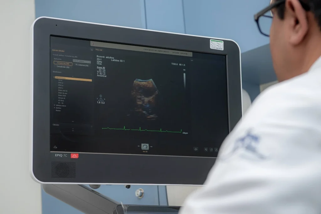 Médico que forma parte del mejor centro cardiovascular en CDMX, en el Centro Médico ABC, revisando un ultrasonido Doppler.