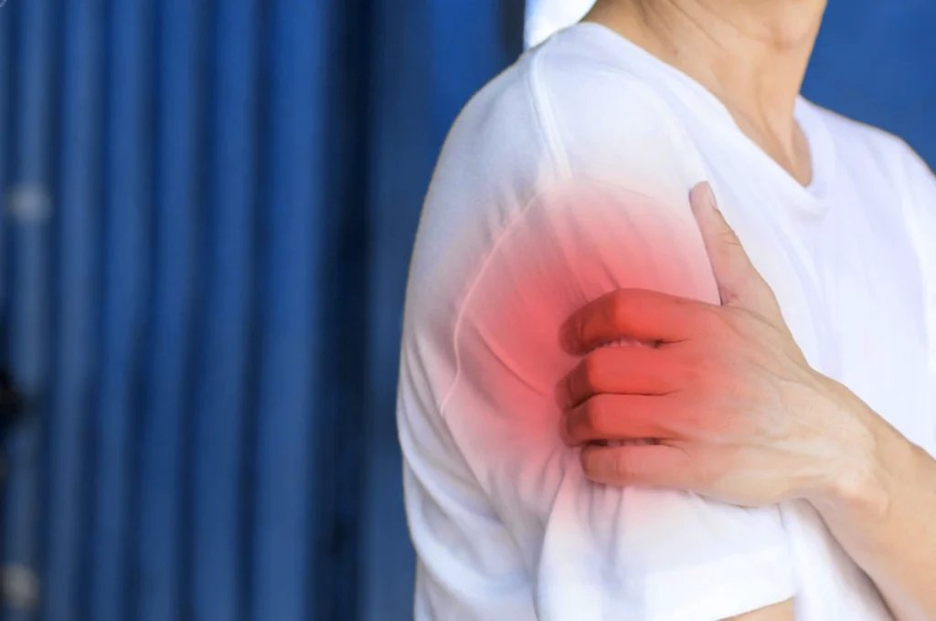 Paciente de osteogénesis imperfecta, sosteniendo el brazo por encima de la playera.