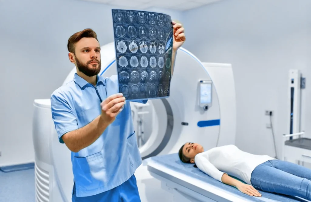 Médico revisa los escaneos cerebrales de una paciente a la que se le realizó una tomografía computarizada.