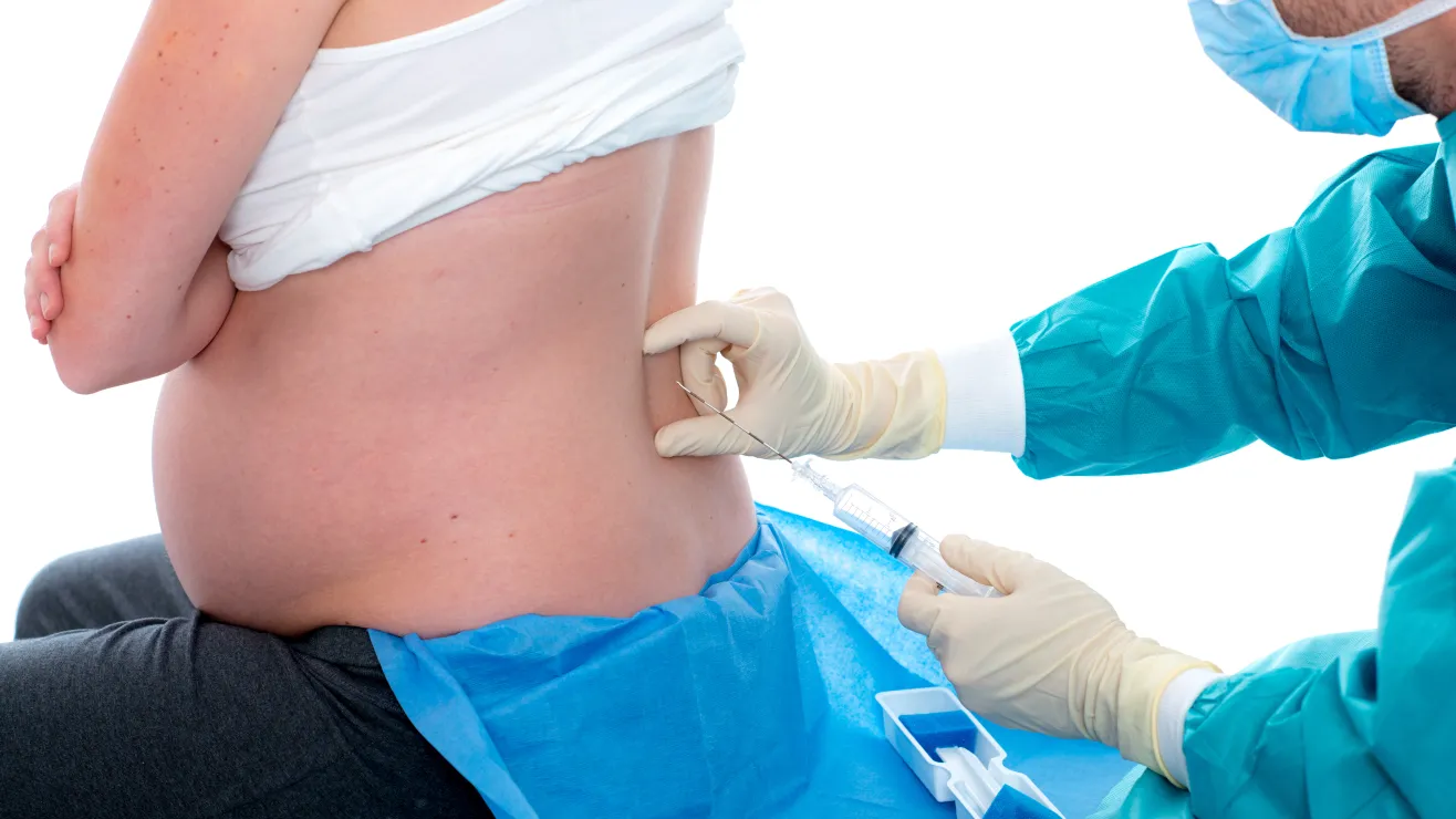 Mujer a punto de recibir una inyección epidural por parte de su médico, para continuar con la labor de parto. Mujer a punto de recibir una inyección epidural por parte de su médico, para continuar con la labor de parto.