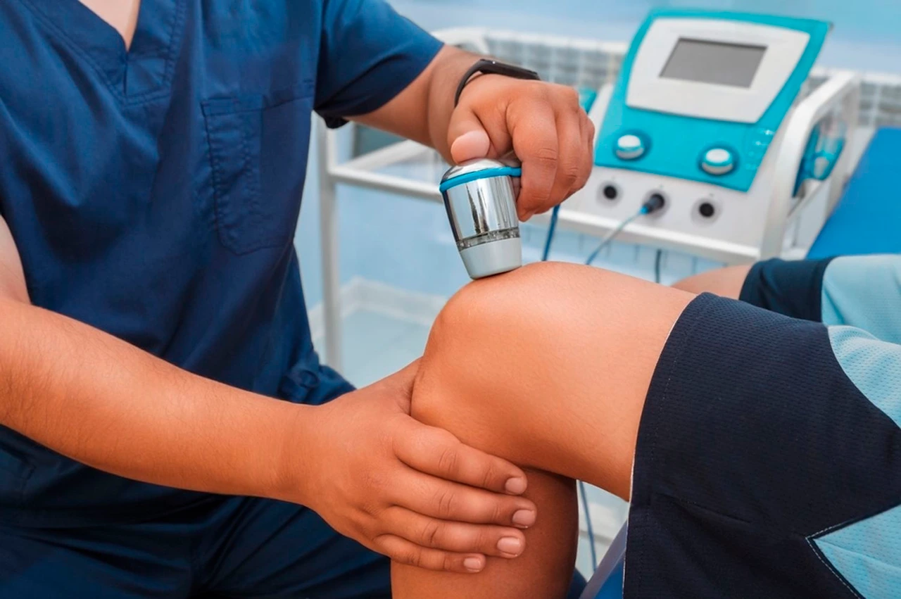 Especialista en fisioterapia y rehabilitación realizando una sesión de ultrasonido en la rodilla a un paciente. Especialista en fisioterapia y rehabilitación realizando una sesión de ultrasonido en la rodilla a un paciente.