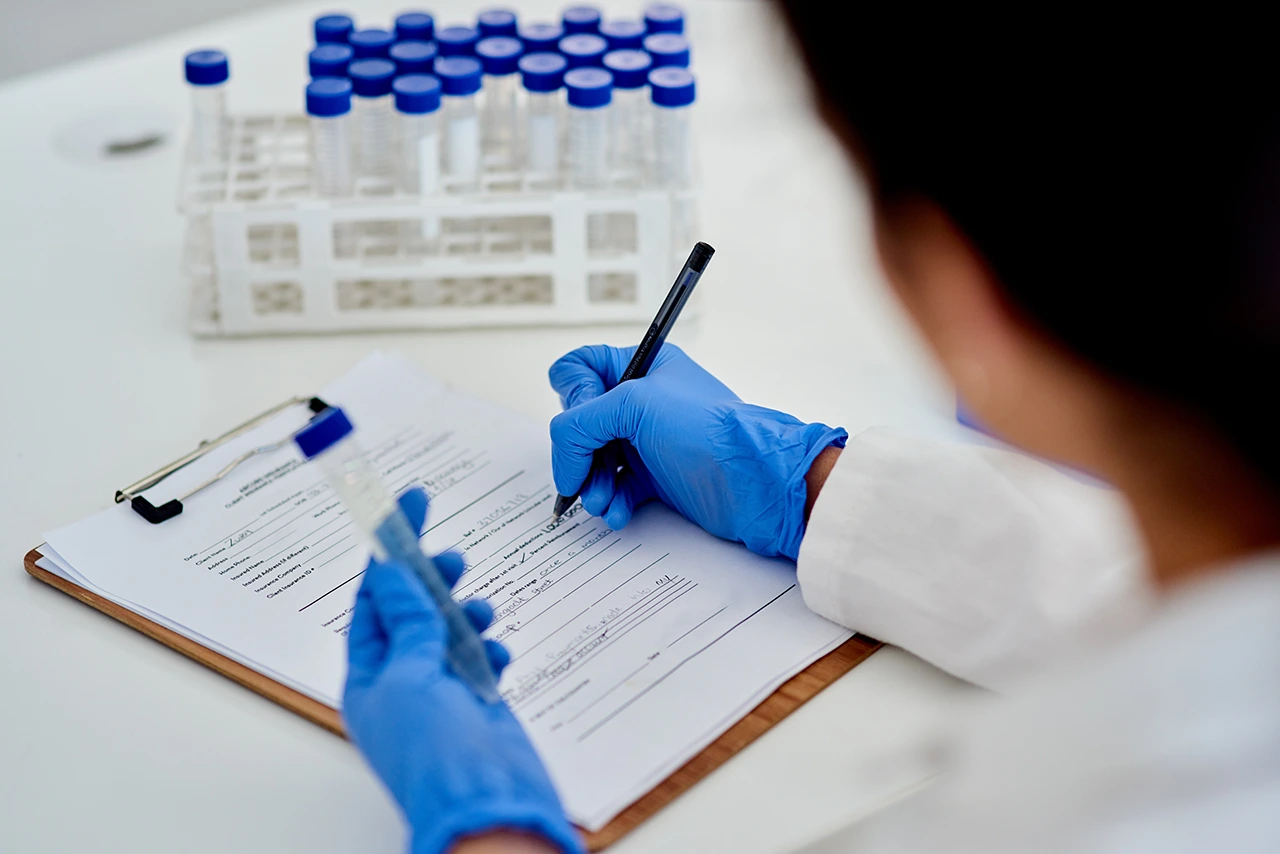 Especialista en microbiología llenando la información obtenida tras el análisis de los patógenos. Especialista en microbiología llenando la información obtenida tras el análisis de los patógenos.